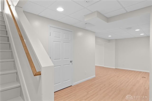 finished below grade area with recessed lighting, wood finished floors, baseboards, and stairs