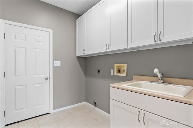 washroom with cabinet space, baseboards, hookup for a washing machine, electric dryer hookup, and a sink