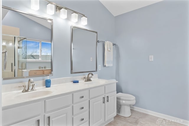 bathroom with double vanity, a sink, toilet, and a shower stall