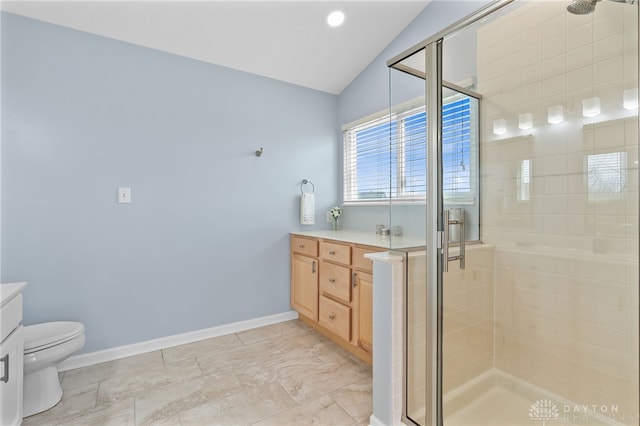 bathroom featuring baseboards, vaulted ceiling, vanity, and a shower stall