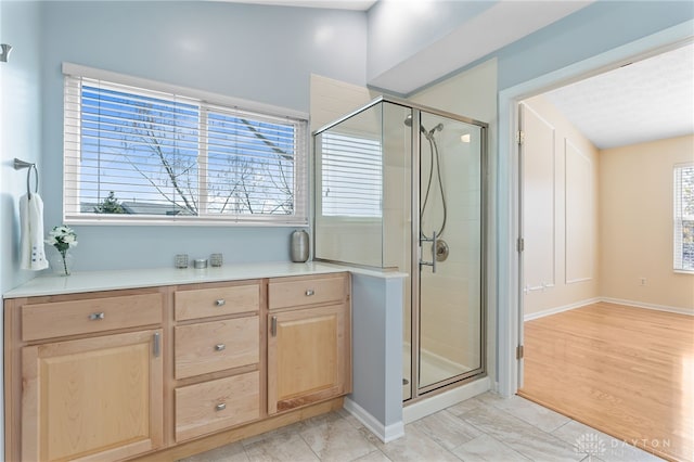 bathroom featuring a shower stall and baseboards