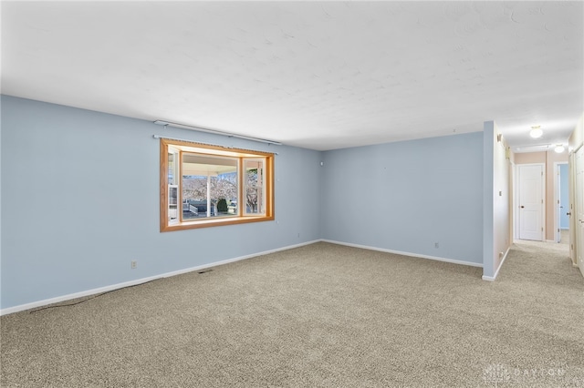 unfurnished room featuring carpet floors and baseboards