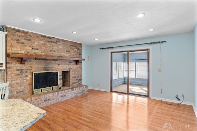 unfurnished living room featuring light wood-style flooring, recessed lighting, a fireplace, visible vents, and baseboards