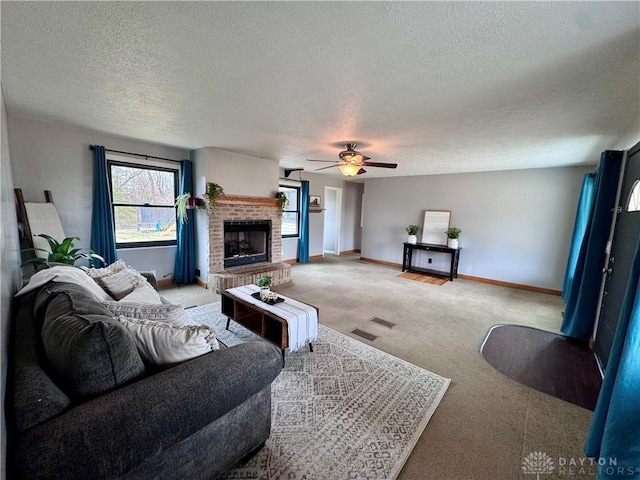 living area featuring light carpet, visible vents, baseboards, ceiling fan, and a brick fireplace