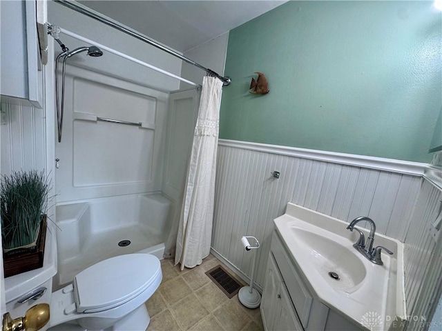 full bath featuring a stall shower, wainscoting, and visible vents