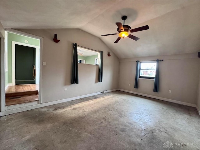 additional living space with unfinished concrete flooring, vaulted ceiling, baseboards, and ceiling fan