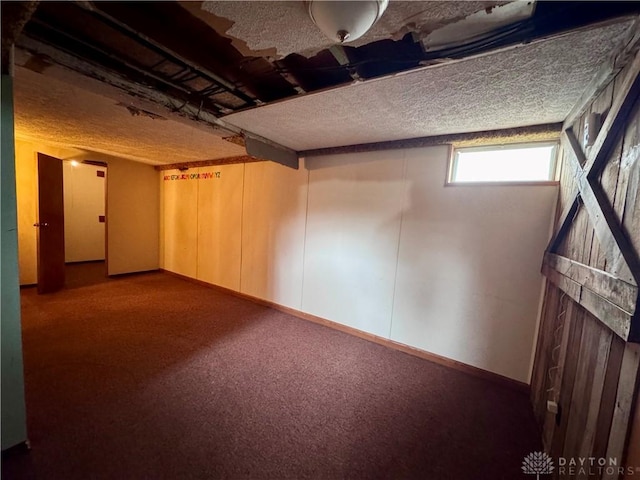 below grade area featuring carpet floors and a textured ceiling