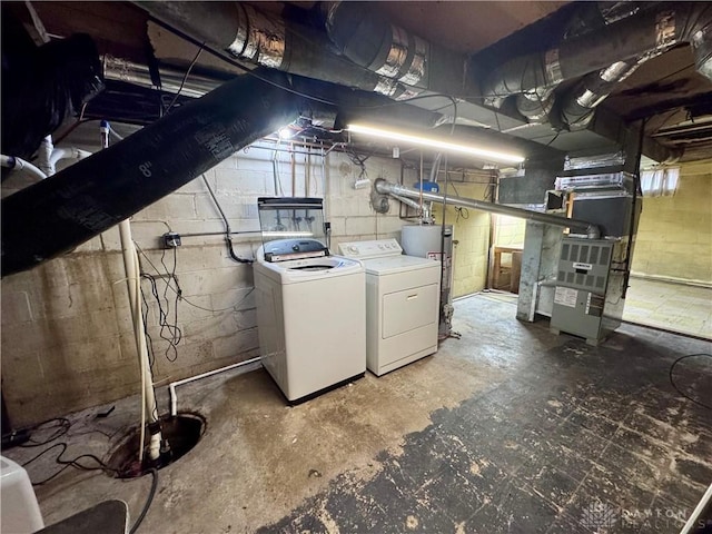 unfinished basement featuring gas water heater, washing machine and dryer, and heating unit