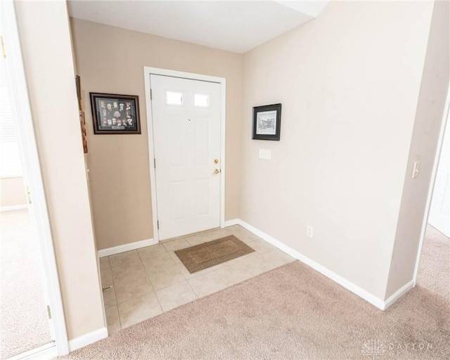 carpeted foyer entrance with tile patterned flooring and baseboards