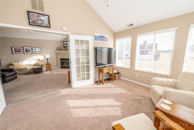 living room featuring carpet floors, a fireplace, high vaulted ceiling, and visible vents