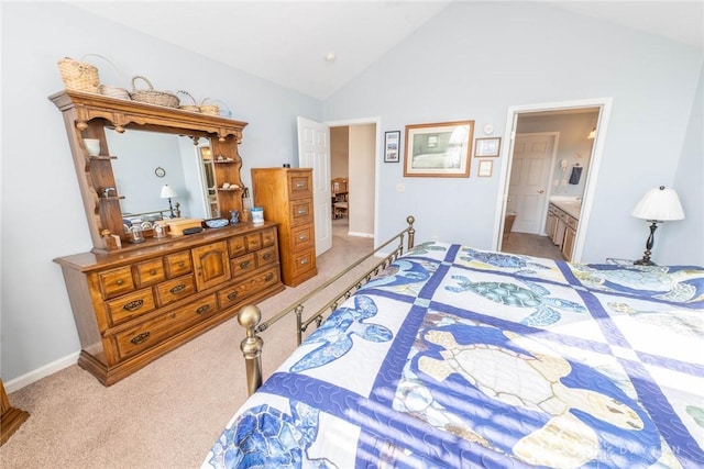 bedroom featuring lofted ceiling, light carpet, baseboards, and ensuite bathroom