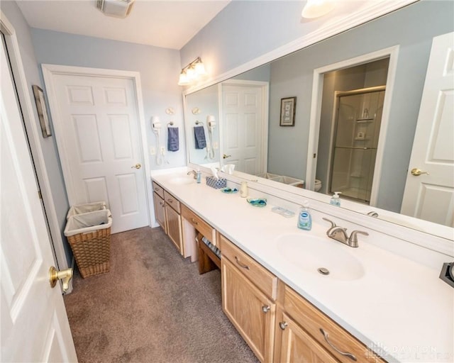 bathroom with visible vents, a sink, a shower stall, and double vanity