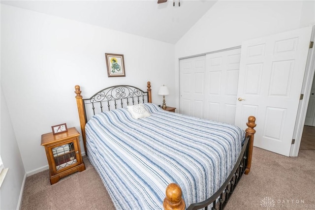 carpeted bedroom with vaulted ceiling, a closet, and a ceiling fan