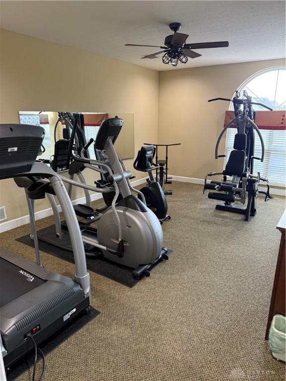 gym featuring ceiling fan and baseboards