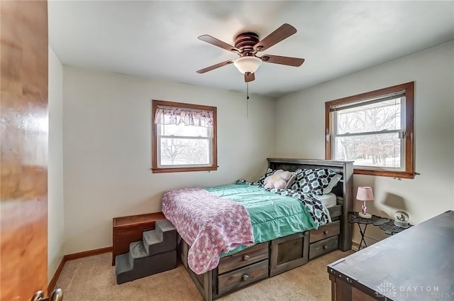 bedroom featuring baseboards, a ceiling fan, and light colored carpet