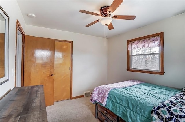 bedroom with light colored carpet, ceiling fan, visible vents, and baseboards