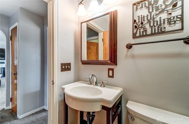 half bathroom with toilet and baseboards