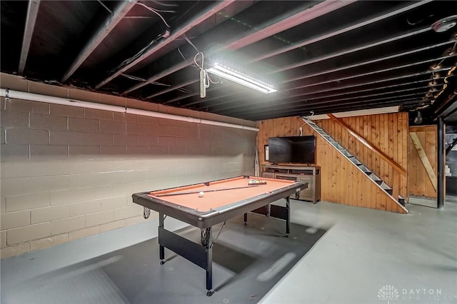 recreation room featuring wood walls, billiards, concrete block wall, and finished concrete floors