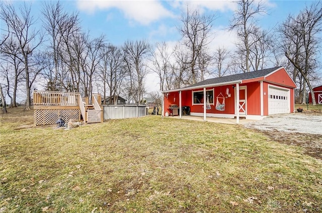 view of yard with a garage, an outdoor structure, and a deck