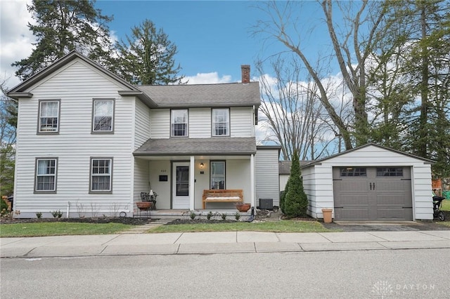 traditional-style home featuring a porch, central air condition unit, a garage, an outdoor structure, and a chimney