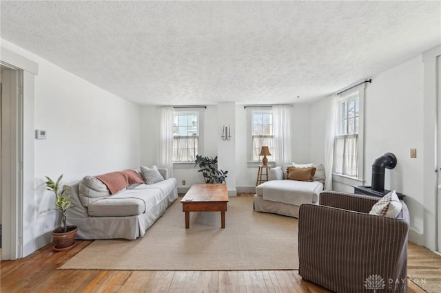 living room with wood-type flooring, baseboards, and a textured ceiling