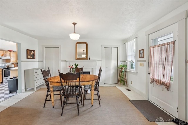 dining room featuring a fireplace, visible vents, and a textured ceiling