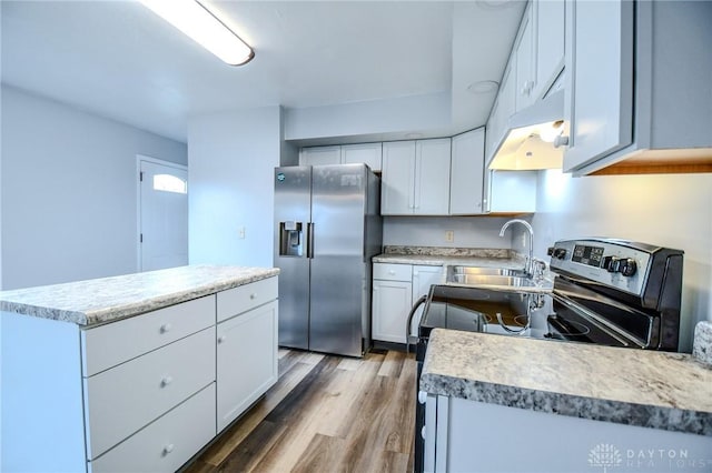 kitchen with white cabinets, light wood-style flooring, stainless steel appliances, light countertops, and a sink