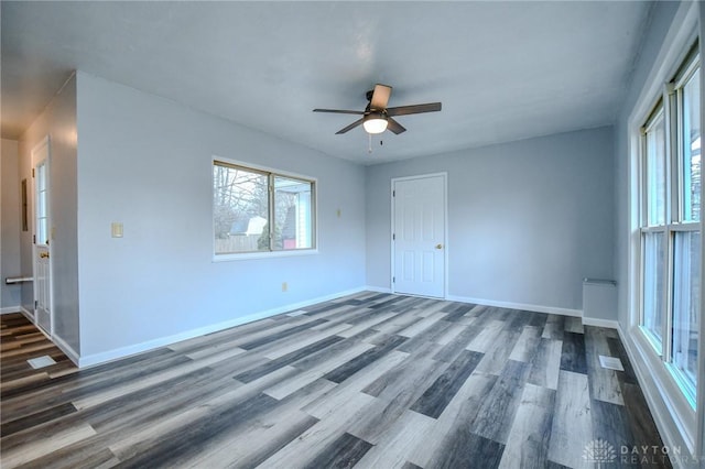 spare room featuring a ceiling fan, baseboards, and wood finished floors