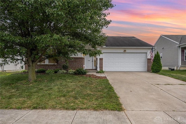 view of front facade featuring concrete driveway, brick siding, a lawn, and an attached garage