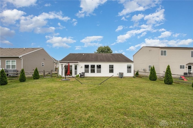 back of house with a fenced backyard, central AC unit, and a lawn