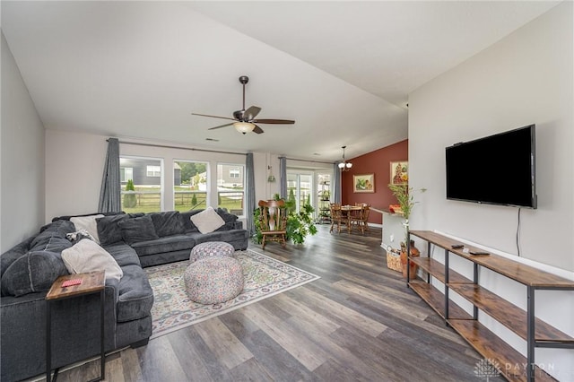 living room featuring ceiling fan with notable chandelier, vaulted ceiling, and wood finished floors