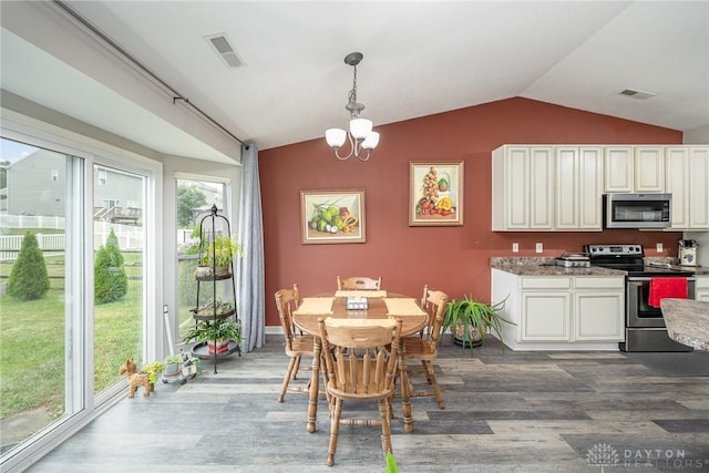 kitchen featuring visible vents, appliances with stainless steel finishes, wood finished floors, vaulted ceiling, and a chandelier