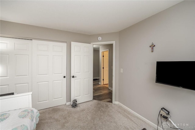 unfurnished bedroom featuring carpet floors, a closet, and baseboards