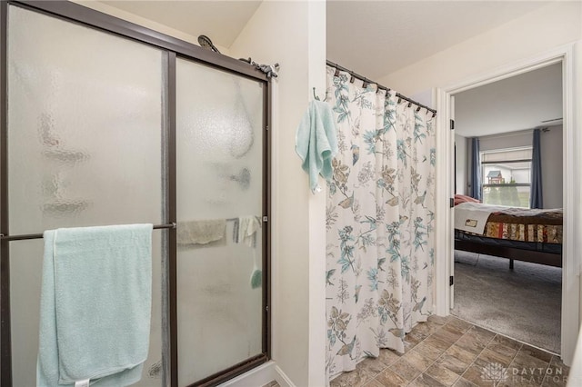 bathroom featuring a stall shower, stone finish flooring, and ensuite bath