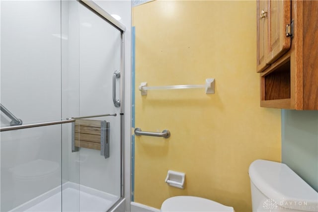 bathroom featuring a stall shower and toilet