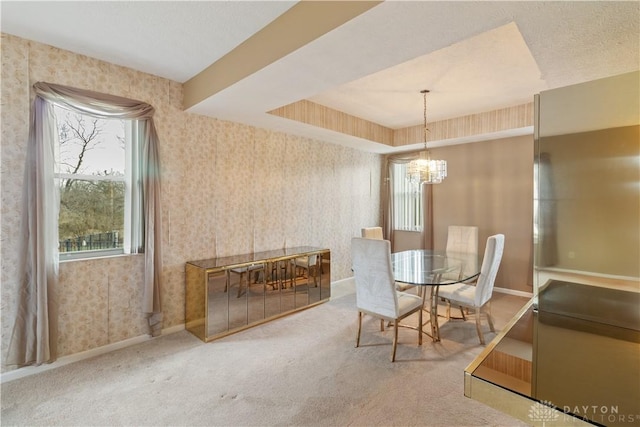 carpeted dining space featuring a chandelier, baseboards, and wallpapered walls