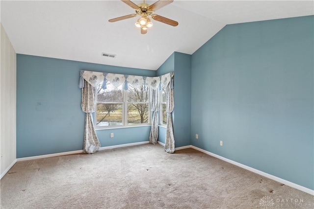 carpeted empty room featuring vaulted ceiling, visible vents, a ceiling fan, and baseboards