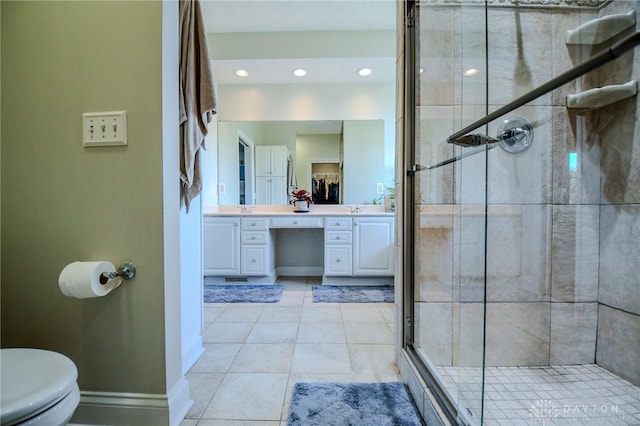 bathroom featuring baseboards, toilet, tile patterned flooring, vanity, and a shower stall