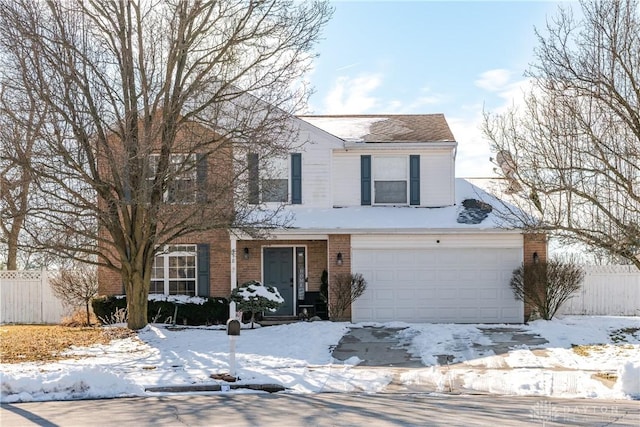 traditional-style home with a garage, brick siding, and fence