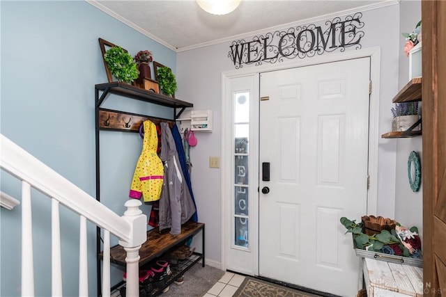 entrance foyer featuring stairway, ornamental molding, a textured ceiling, and tile patterned floors