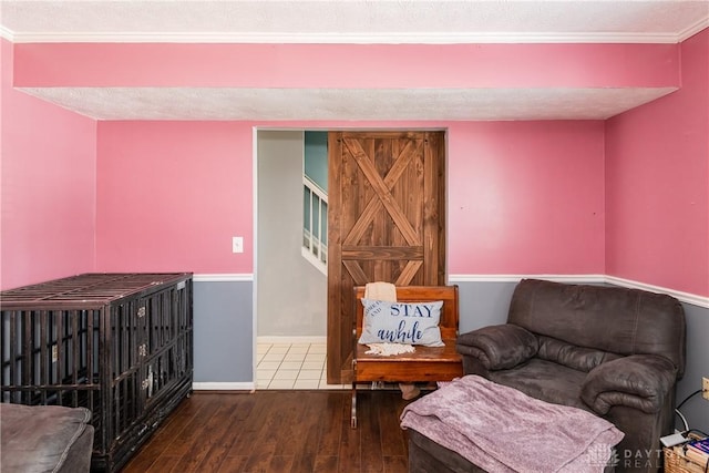 living area featuring wood-type flooring, a textured ceiling, and baseboards