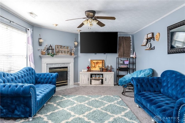 carpeted living room featuring a textured ceiling, a fireplace, visible vents, a ceiling fan, and ornamental molding