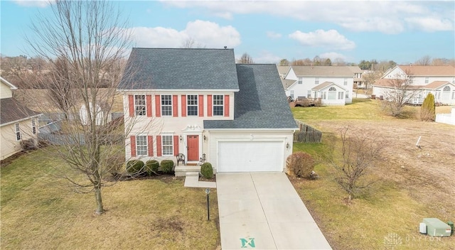 colonial inspired home with a front yard, concrete driveway, roof with shingles, and a residential view