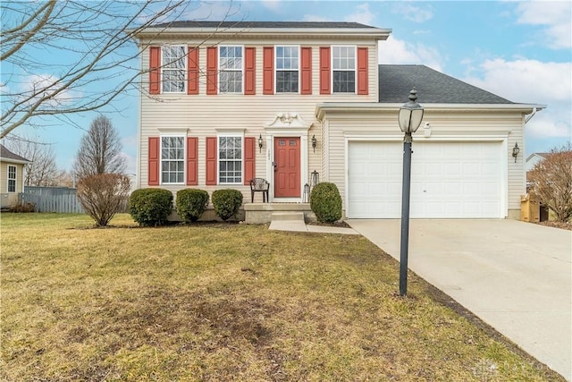 colonial home with a front yard, concrete driveway, and an attached garage