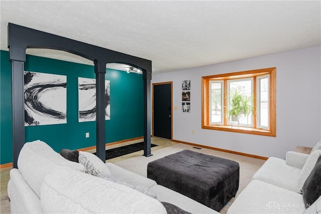 living room featuring visible vents, carpet flooring, a textured ceiling, and baseboards