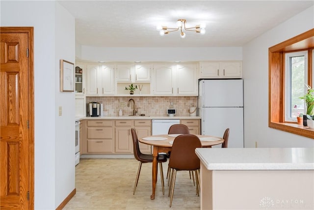 kitchen featuring open shelves, tasteful backsplash, light countertops, a sink, and white appliances