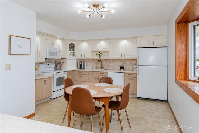 kitchen featuring white appliances, decorative backsplash, light countertops, and light floors