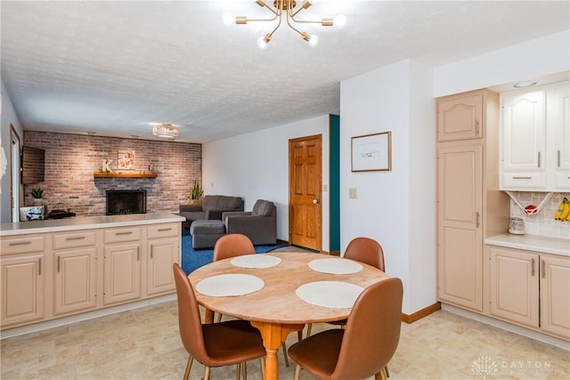 dining room featuring an inviting chandelier, a fireplace, baseboards, and a textured ceiling