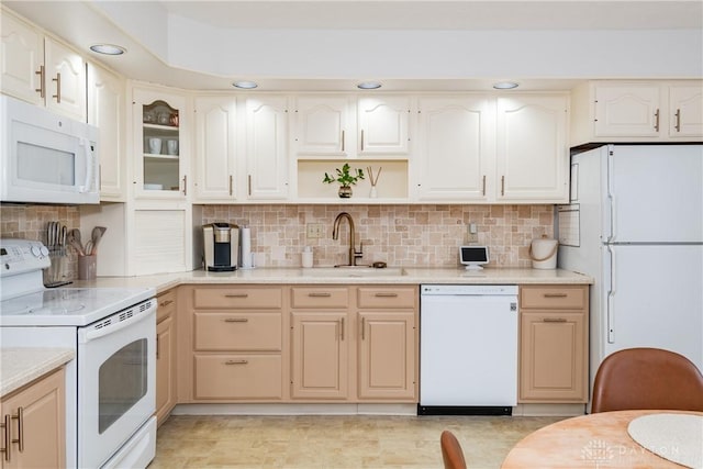 kitchen featuring light countertops, white appliances, a sink, and tasteful backsplash