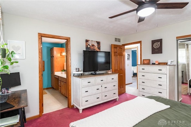 bedroom featuring a textured ceiling, baseboards, visible vents, and light colored carpet